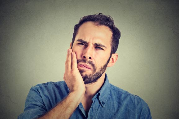 man holding mouth tooth pain